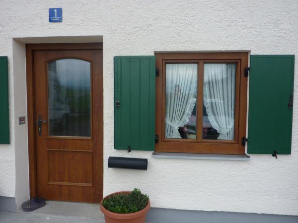 Holztür und -fenster mit grünen Klappläden 