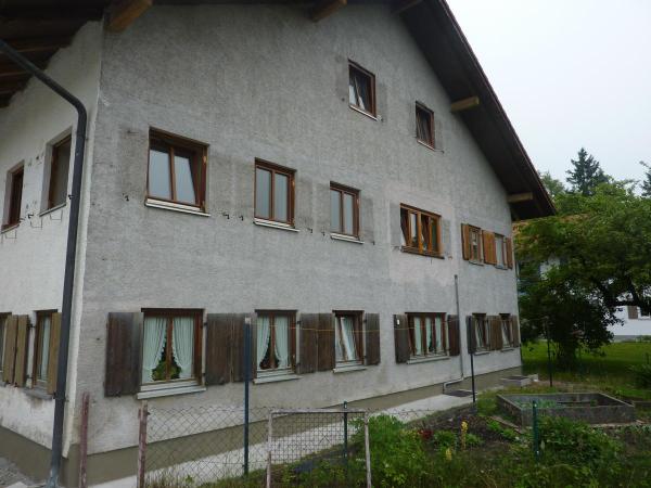 Hausfassade mit Holzfenstern und Klappläden 