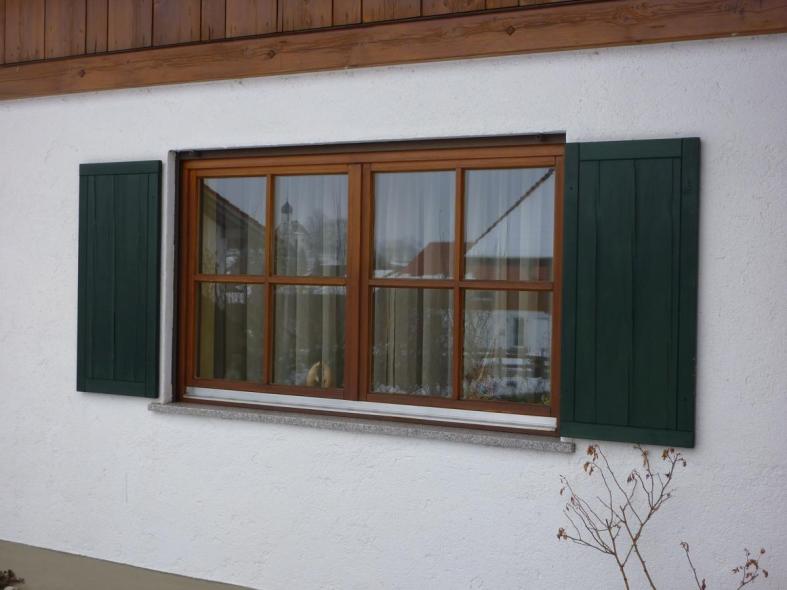 Holz-Sprossenfenster mit grünen Klappläden 